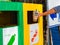 Closeup portrait woman hand throwing empty coffee plastic cup in recycling bin.