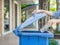 Closeup portrait woman hand throwing empty plastic water bottle in recycling bin.