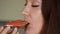Closeup portrait of a woman who eating a sandwich with red fish and butter. Girl bites a salmon sandwich
