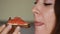 Closeup portrait of a woman who eating a sandwich with red fish and butter. Girl bites a salmon sandwich