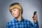 Closeup Portrait of worried stressed boy with mobile going irritation on gray background