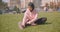 Closeup portrait of young attractive african american muslim girl in hijab stretching sitting on grass being relaxed in