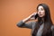 Closeup portrait of a young beautiful brunette pensive woman holding her smartphone and listening, thinking about something