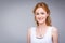 Closeup portrait young, beautiful business woman, student with lred, curly hair and freckles on face on gray background in the stu