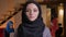 Closeup portrait of young beautiful successful muslim businesswoman in black hijab looking at camera being on the