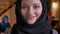 Closeup portrait of young beautiful successful muslim businesswoman in black hijab looking at camera and smiling