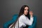 Closeup portrait of young beautiful woman with with beautiful long hair. Sitting and posing in studio. Portrait of trendy, cheerfu