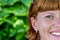 Closeup portrait of young beautiful woman on green leafs back. Tropical lady scene. Bali island.