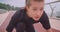 Closeup portrait of young caucasian sporty female jogger in a black tshirt sitting in a start position and running on