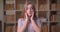 Closeup portrait of young cheerful caucasian female student being excited and surprised looking at camera in the college