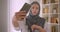 Closeup portrait of young cheerful pretty Arabian businesswoman in hijab taking selfies on phone posing sitting in front