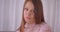 Closeup portrait of young cute caucasian female looking at camera with confidence indoors in apartment