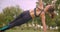 Closeup portrait of young cute sporty fitness girl doing side plank exercise stretching her arm in the park in urban