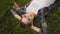 Closeup portrait, young happy girl is lying in the grass and smiling. Woman face with glasses 4K