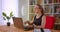 Closeup portrait of young pretty redhead businesswoman in glasses using laptop being thoughtful in office indoors with