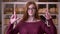 Closeup portrait of young redhead attractive caucasian female student in glasses having her fingers crossed with anxiety