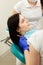 Closeup portrait of young woman patient, sitting in dentist chair. Doctor examines the teeth. Dental health prevention