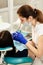 Closeup portrait of young woman patient, sitting in dentist chair. Doctor examines the teeth. Dental health prevention