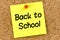 Closeup post it note on corkboard with back to school  message on it