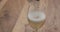 Closeup pour apple cider in a wine glass on wood table