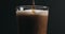 Closeup pour dark stout beer in pint glass over black background