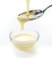 Closeup pouring condensed milk with teaspoon