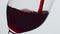 Closeup pouring red wine glass indoors. Alcoholic liquid filling wineglass