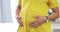 Closeup, pregnant and woman touching stomach, care and maternity with health, natural birth and loving. Zoom, female and