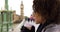 Closeup of pretty black female standing on Westminster Bridge and sipping coffee