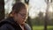 Closeup pretty girl sitting in sunny park. Teenager girl reading outdoors