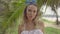 Closeup of pretty naturally looking woman wearing white bikini top and blue headband bow on a beautiful summer day walking and