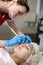 Closeup of Professional Female Beautician Tattooing Woman`s Eyebrows Using Special Marking Equipment While Permanent Make-up