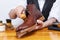 Closeup of Professional Male Shoes Cleaner with Cleaning Brushes For Tan Derby Leather Boots While Working in Workshop With Rub