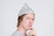 Closeup profile view of young man with tinfoil hat thinking and looking at camera