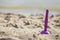 Closeup of purple beach scoop in the sand, game for child