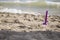 Closeup of purple beach scoop in the sand, game for child