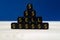 Closeup of a pyramid  of black cubes with gold Dollar signs and text sell on them