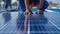 A closeup of a quality control inspection with workers carefully examining the surface of a completed solar panel for