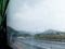 Closeup rain drops on the window of bus while moving on the road with raining