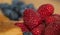 Closeup of Raspberries Next To Pastry And In Front of Blueberries