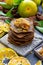 Closeup of raw pancakes with tangerine jam topping on a table surrounded by citruses and leaves