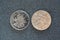 Closeup rear side view of 1 Chinese yuan and 1 dollar hong kong coins isolated on dark background with copy space,