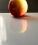 Closeup of a red apple reflecting on the table under the lights with a blurry background