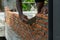 Closeup red bricklayers wall and trowel with dirty hands of worker background