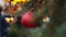 Closeup of red Christmas balls on natural New Year tree on city fair,