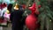 Closeup of a red Christmas decorations hanging on a natural New Year tree on a city fair,