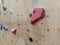 Closeup of red and colorful climbing pieces on a wall in a gym for climbing exercise both for leisure and professionally,