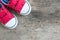 Closeup red fabric sneakers of kid on old wood floor textured background in top view with copy space