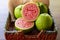 Closeup on red guava sliced with green leaf on rustic wooden background