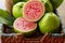 Closeup on red guava sliced with green leaf on rustic wooden background